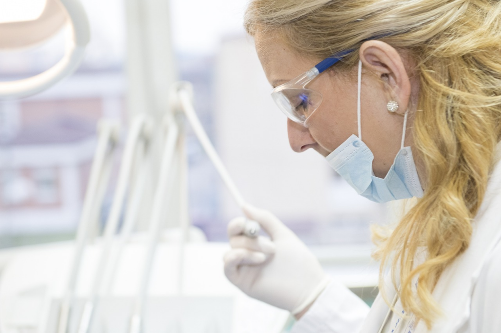 photo of a dental professional doing her work while wearing a mask